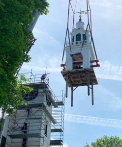 Gilded weathervane by Alexandra Hadik being lifted up on a steeple